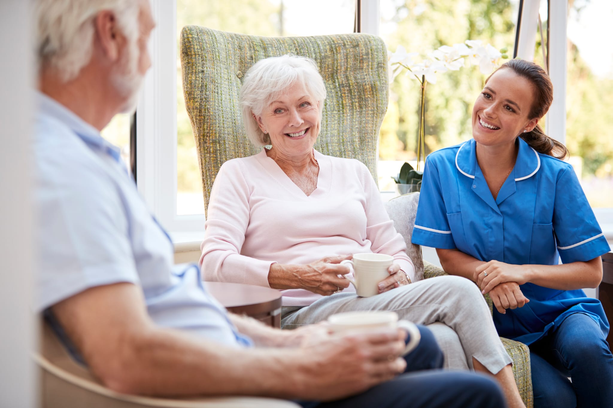 A care professional speaking with an older couple at home